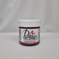 A small jar of Paintables Dye System Primary Red 000 dye, featuring a white lid and a white label with red and black text, set against a draped white fabric background.